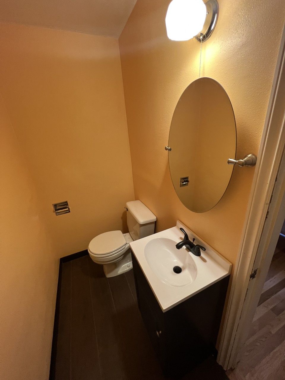 A bathroom with a toilet a sink and a mirror