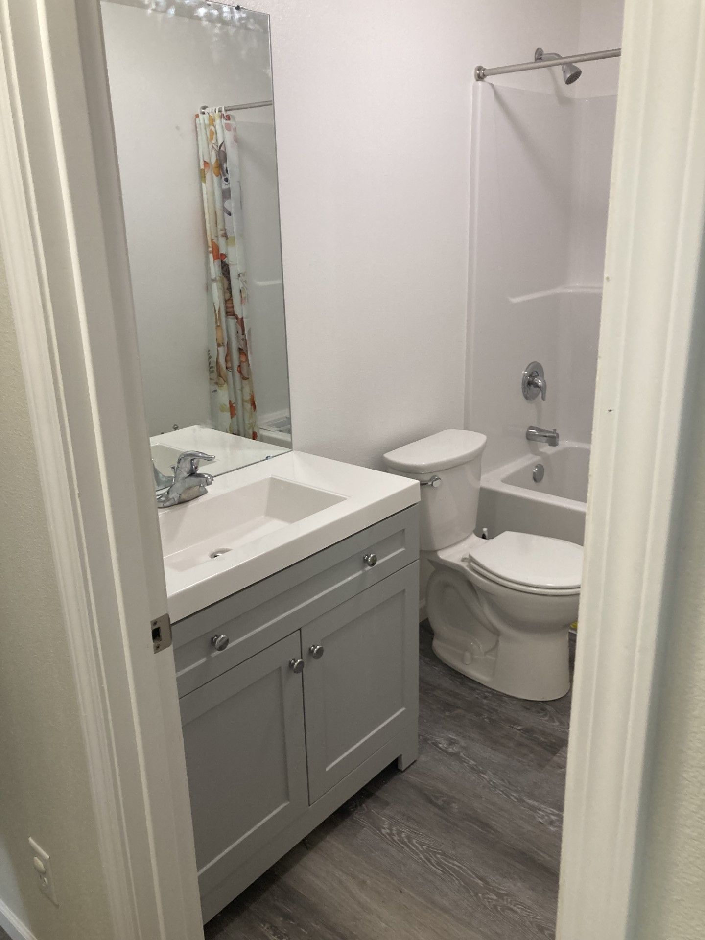 A bathroom with a sink , toilet , tub and mirror.