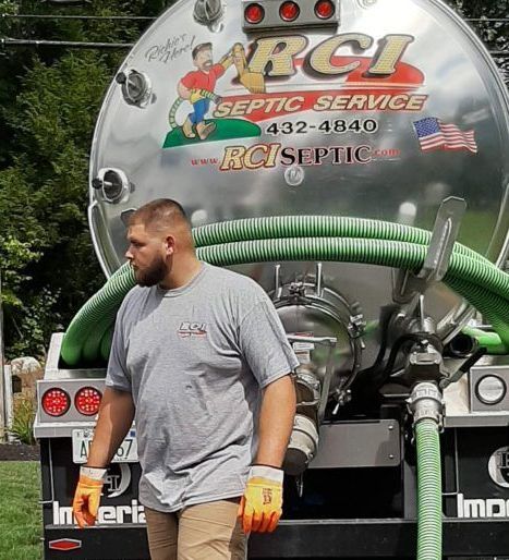 A septic service truck is parked in front of a building