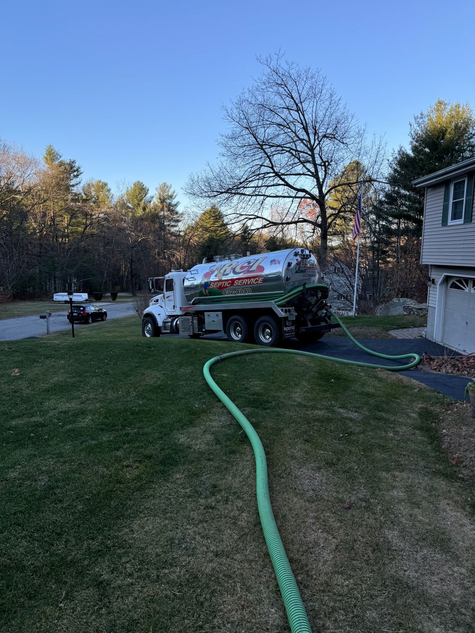 A septic service truck is parked in front of a building