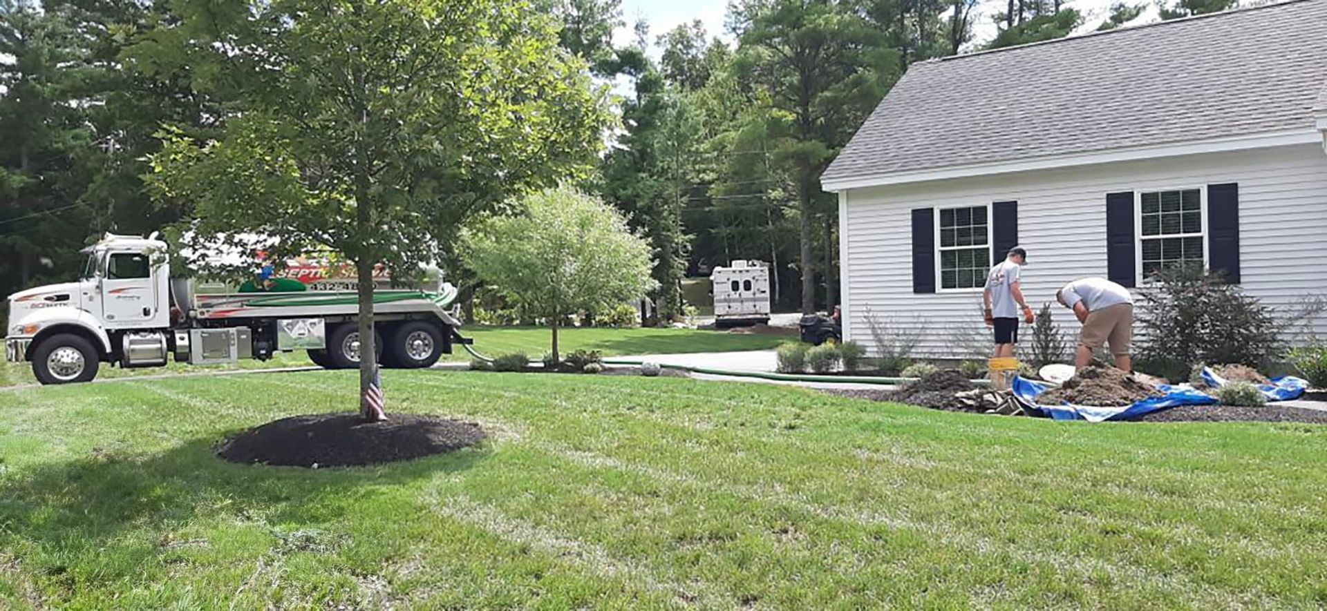 Septic service clean out truck is parked in front of a house.