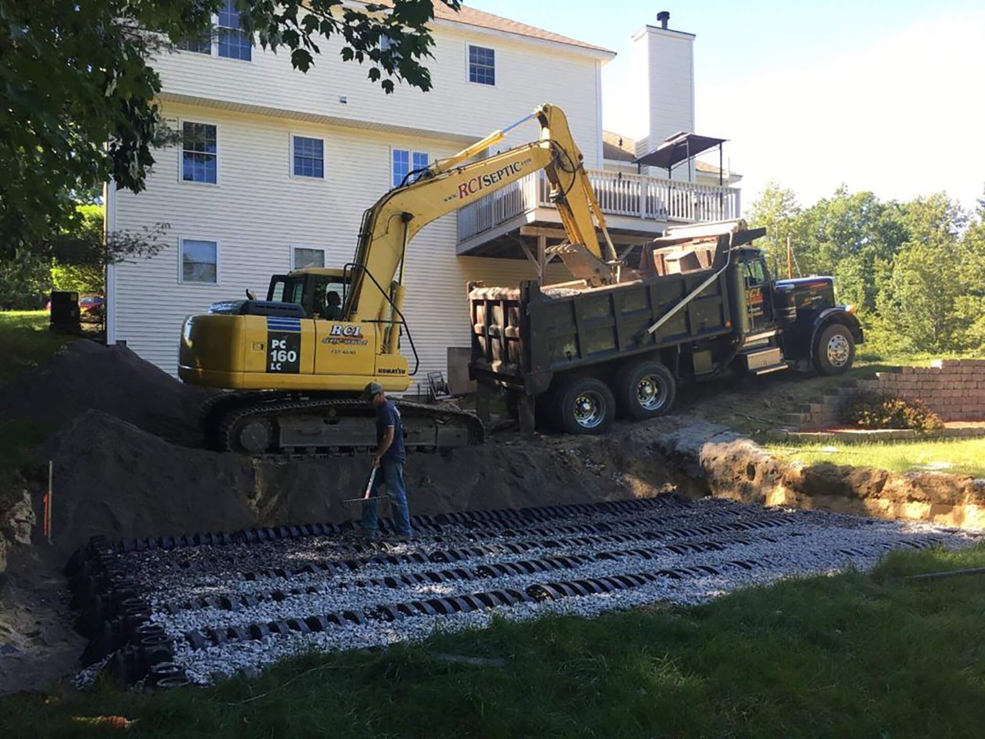 A yellow excavator is loading dirt into a dump truck.