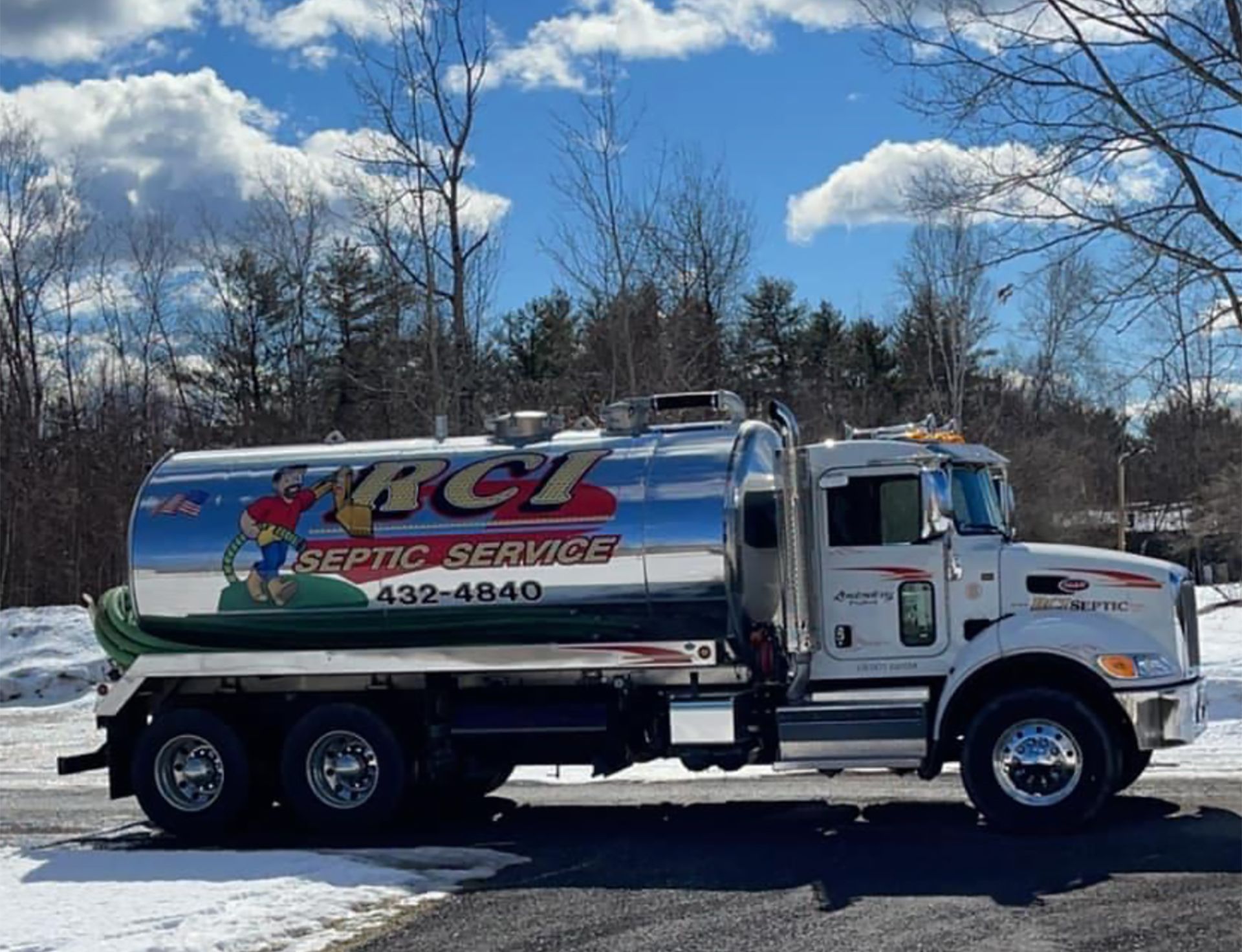 A septic service truck is parked in the snow.