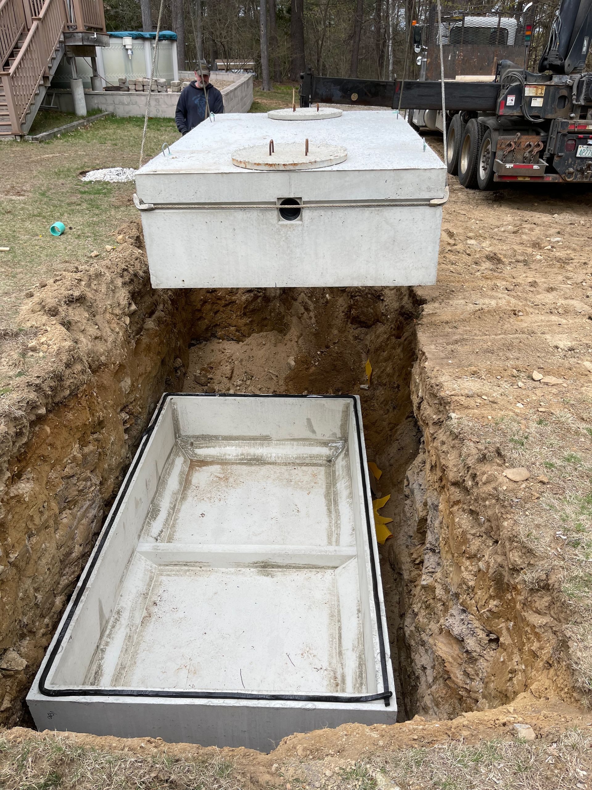 A large concrete box is sitting in the dirt next to a truck.