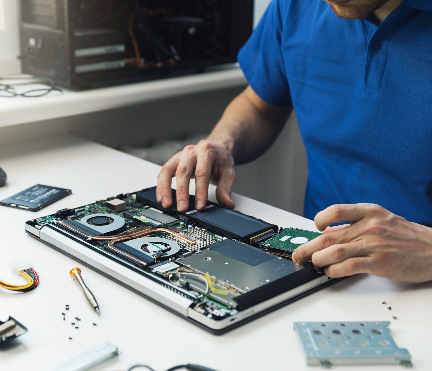 computer repairman installing hard disk drive in laptop