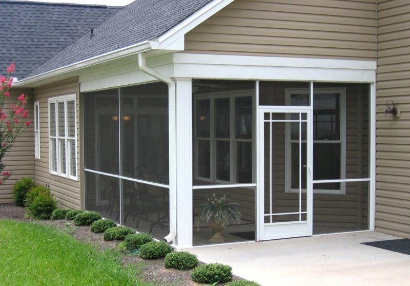 A screened in porch on the side of a house