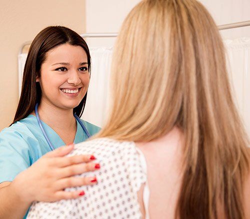  a woman talking to her technologist before a mammogram