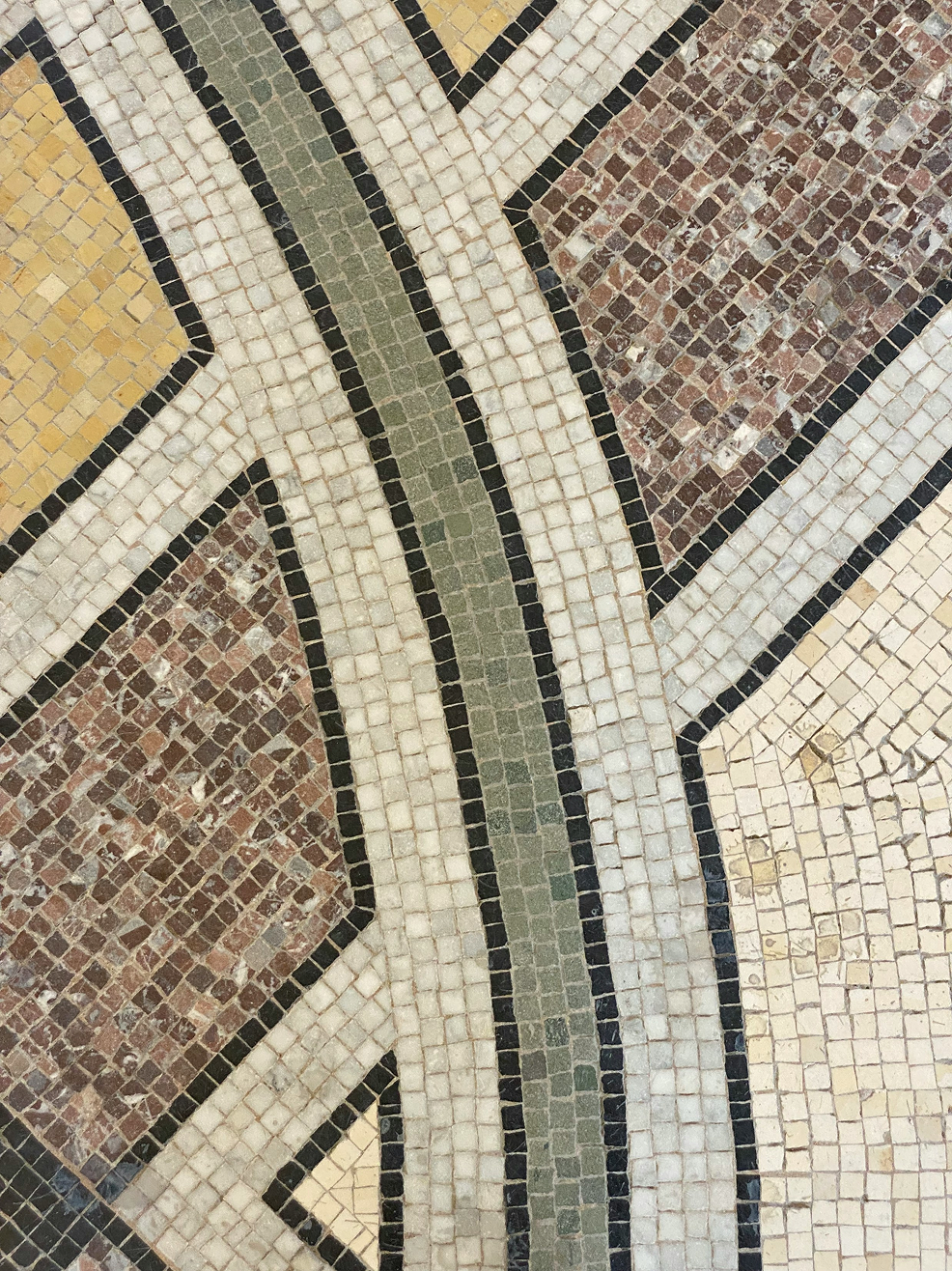 Mosaic tile floor with beige, brown, and green curved design.