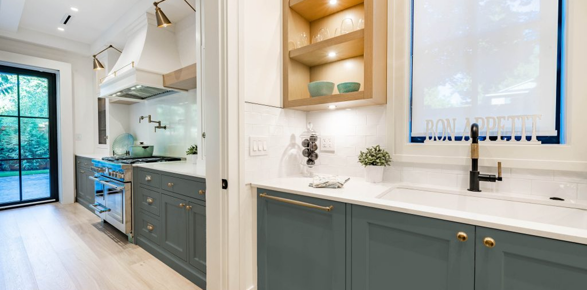 A kitchen with blue cabinets , white counter tops , and a sink.
