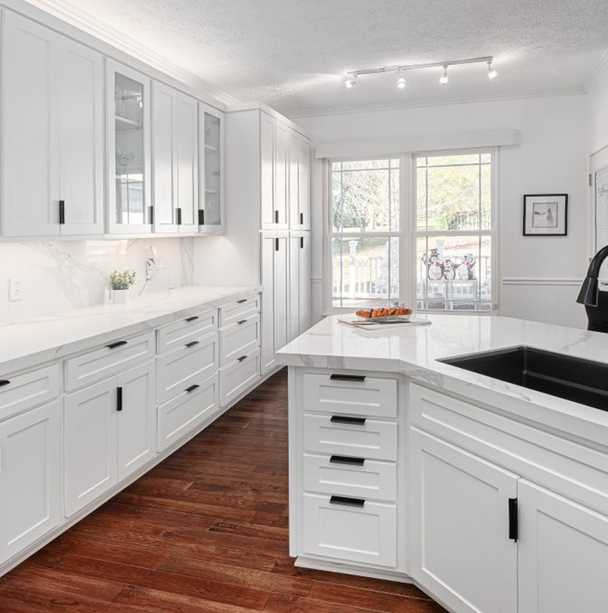A kitchen with white cabinets and a black sink.