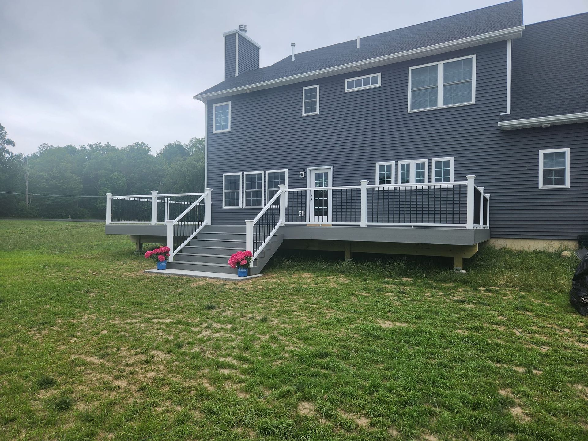 A large house with a large deck in the backyard.