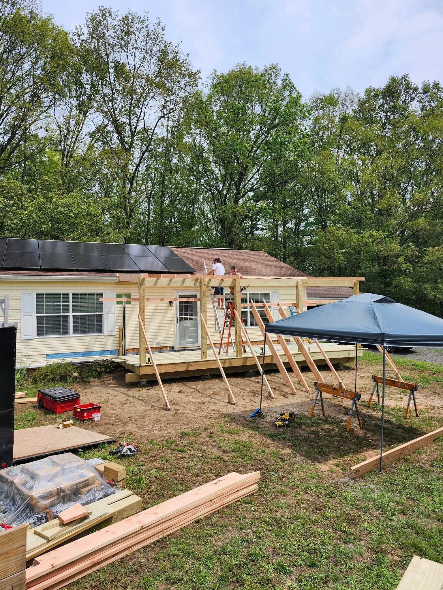 A wooden deck is being built in front of a house.