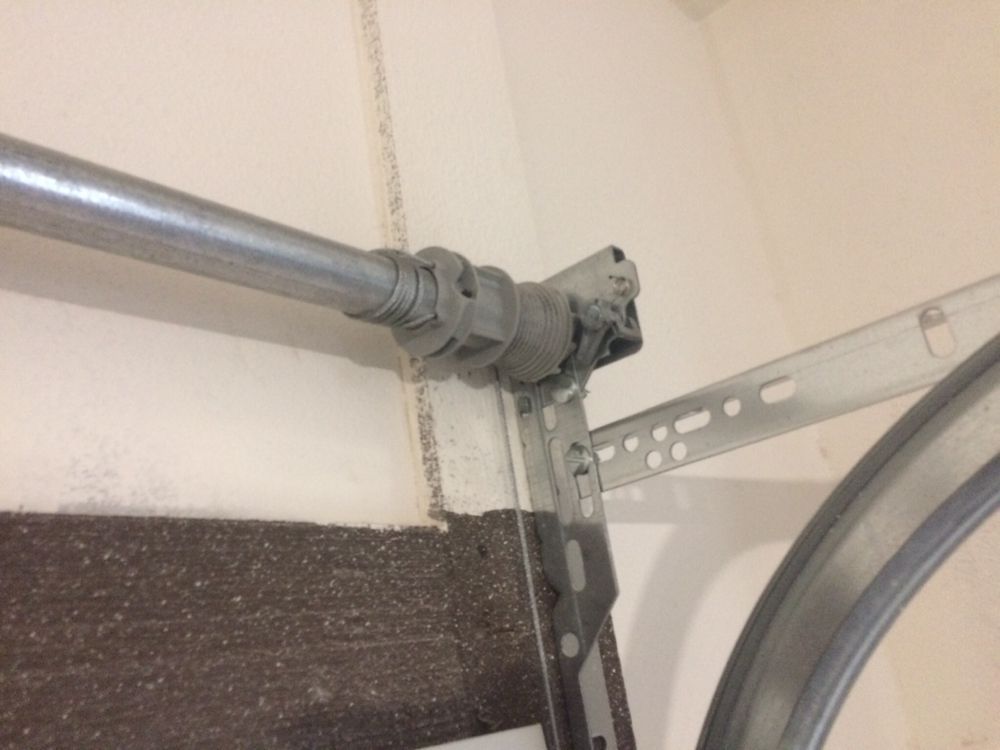 A close up of a metal pipe hanging from a wall.