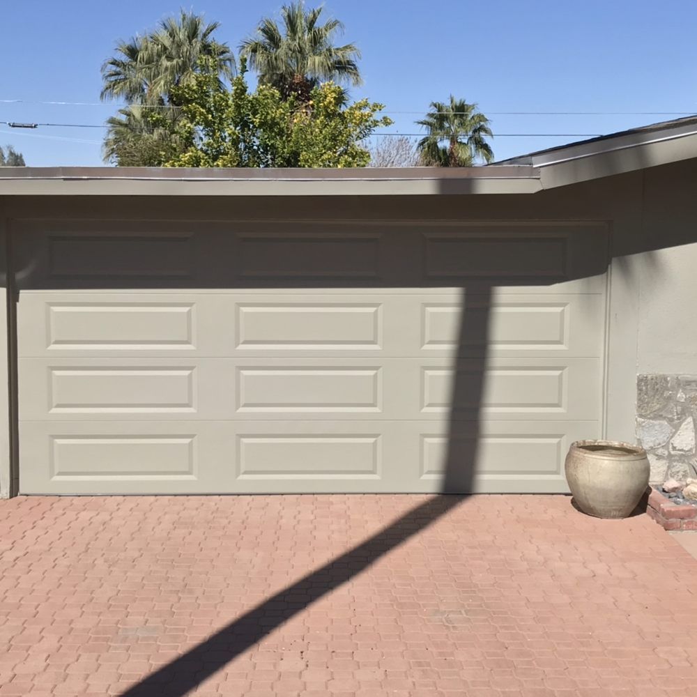 A white garage door with a pot in front of it