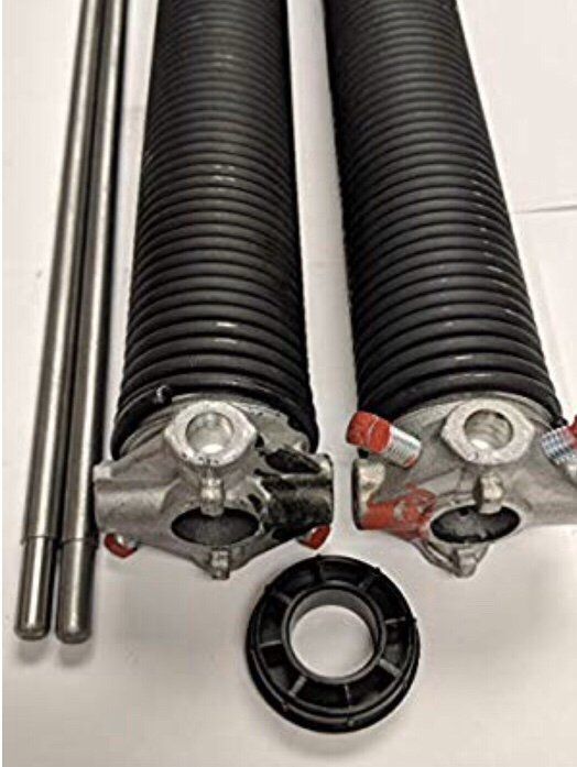 A pair of garage door springs sitting next to each other on a white surface.