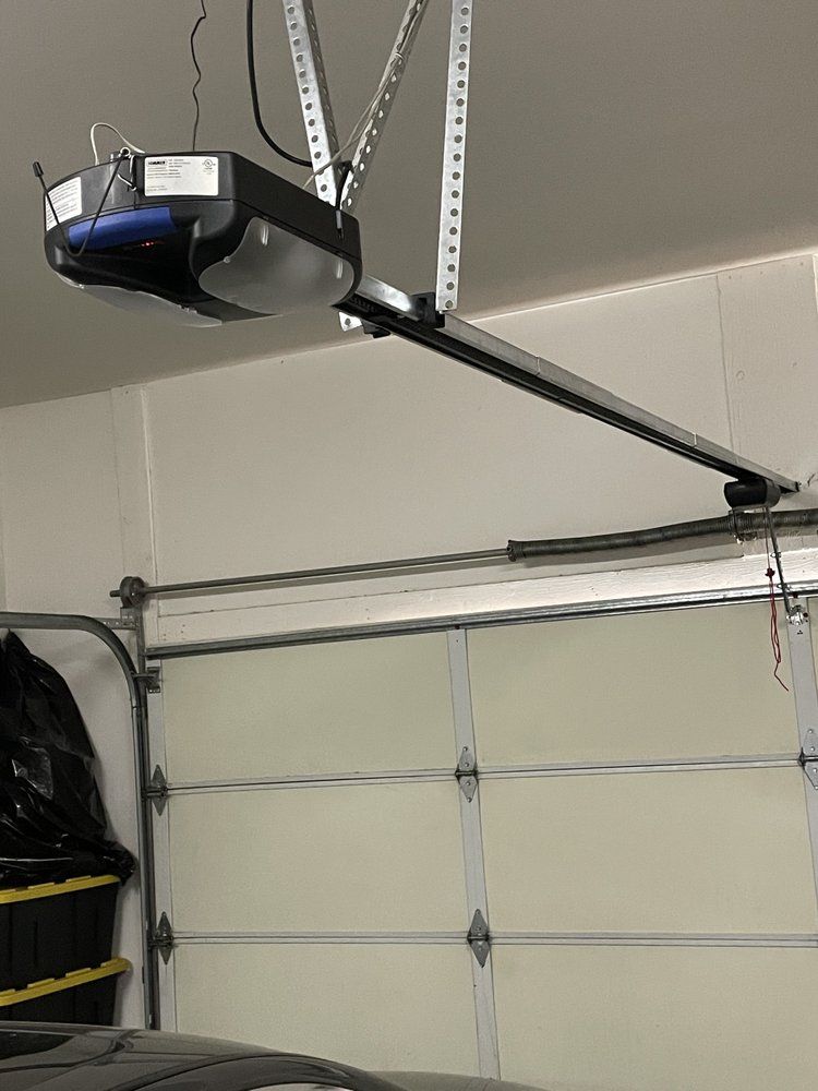 A garage door opener is hanging from the ceiling above a car