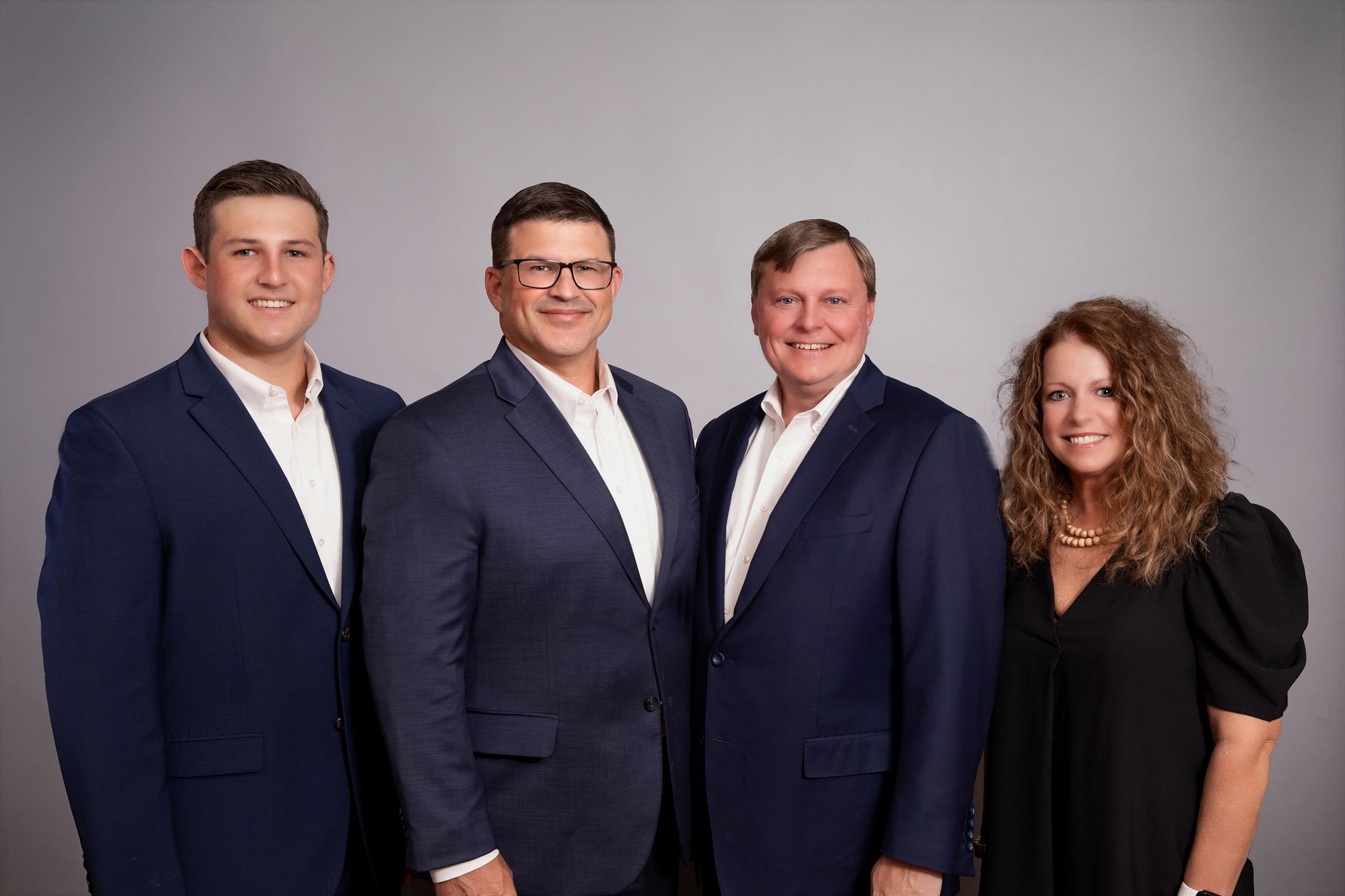 A man with a backpack is standing next to a lake in the woods.