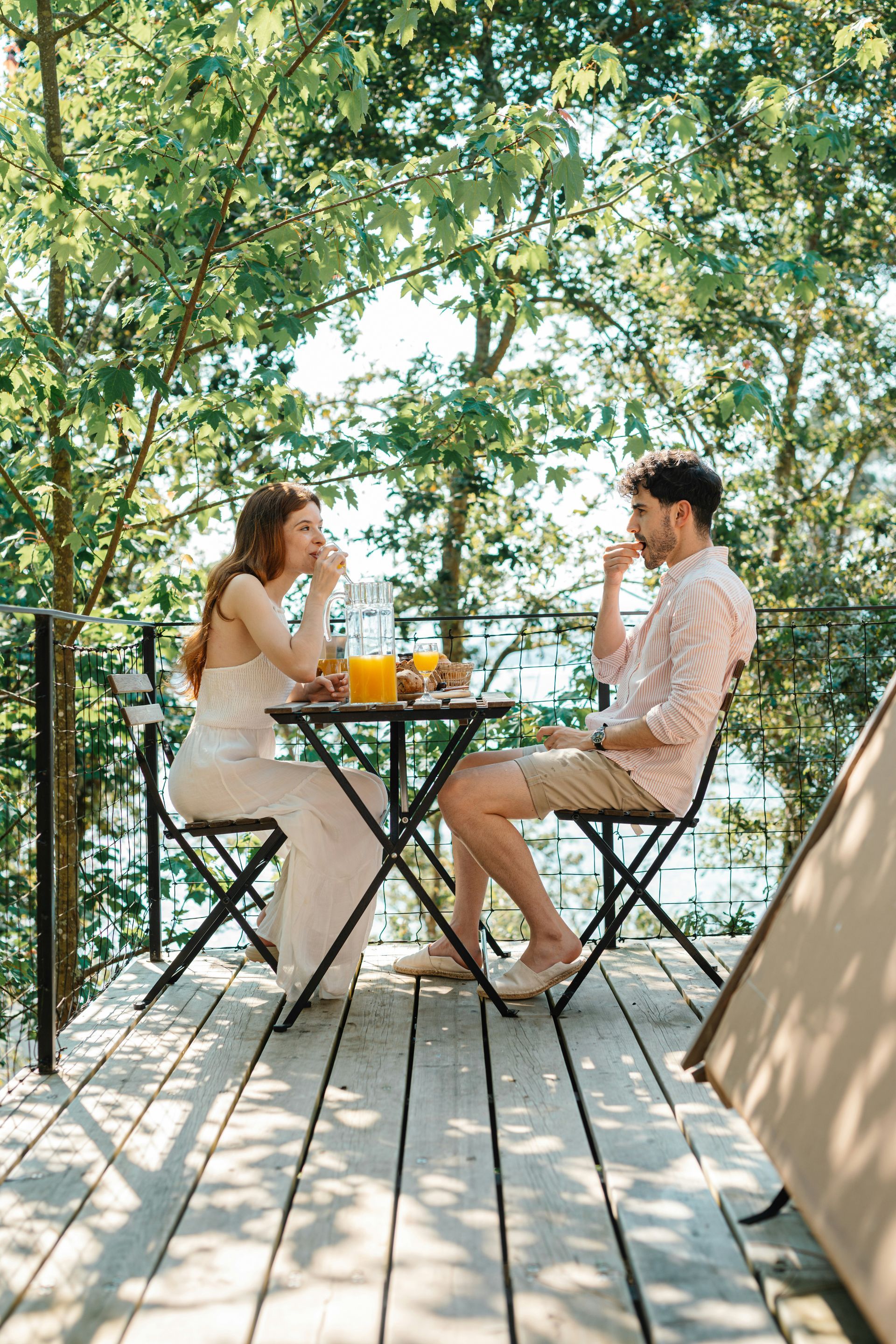 High-rise building under construction with two cranes against a clear blue sky.
