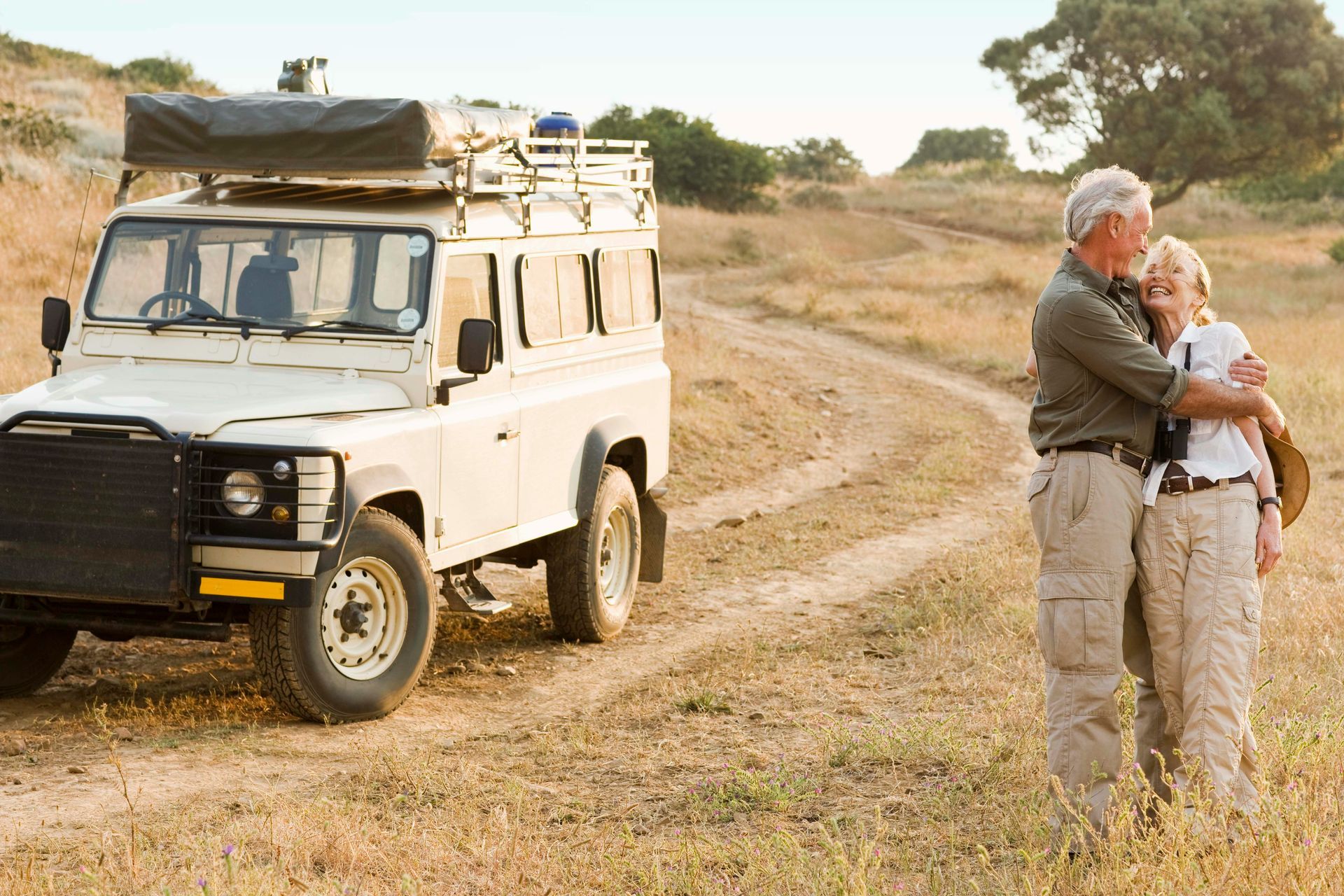 High-rise building under construction with two cranes against a clear blue sky.