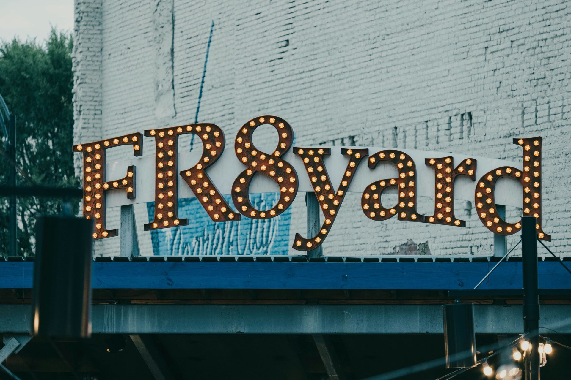 High-rise building under construction with two cranes against a clear blue sky.
