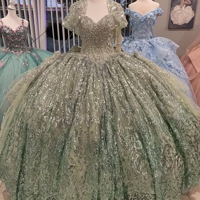 A green ball gown is sitting on top of a mannequin.