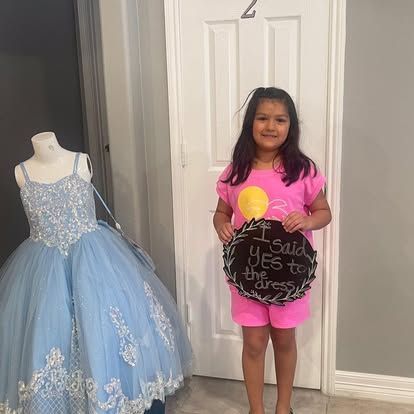 A little girl is holding a sign that says `` i said yes to my dress ''.