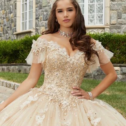 A woman in a ball gown is standing in front of a building