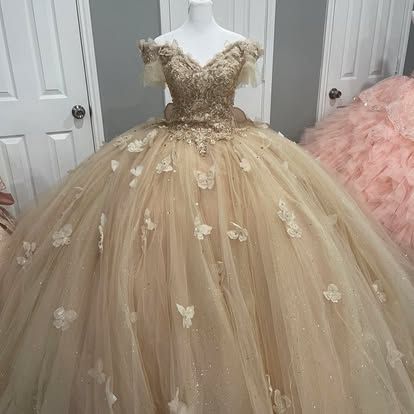 A ball gown with butterflies on it is on a mannequin in a room.