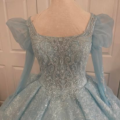 The back of a light blue ball gown is shown on a mannequin.