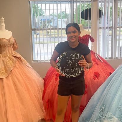 A woman is standing in front of a window holding a sign that says `` i said yes ''.