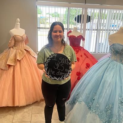 A woman is standing in a room holding a sign that says `` i said yes to the dress ''.