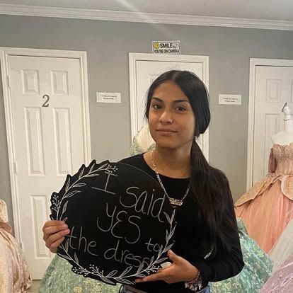 A woman is holding a sign that says `` i said yes to the dress ''.