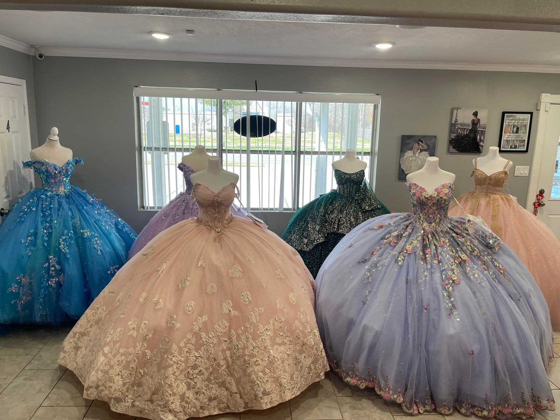 A room filled with lots of dresses on mannequins.