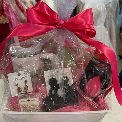 A gift basket filled with jewelry and a pink bow.