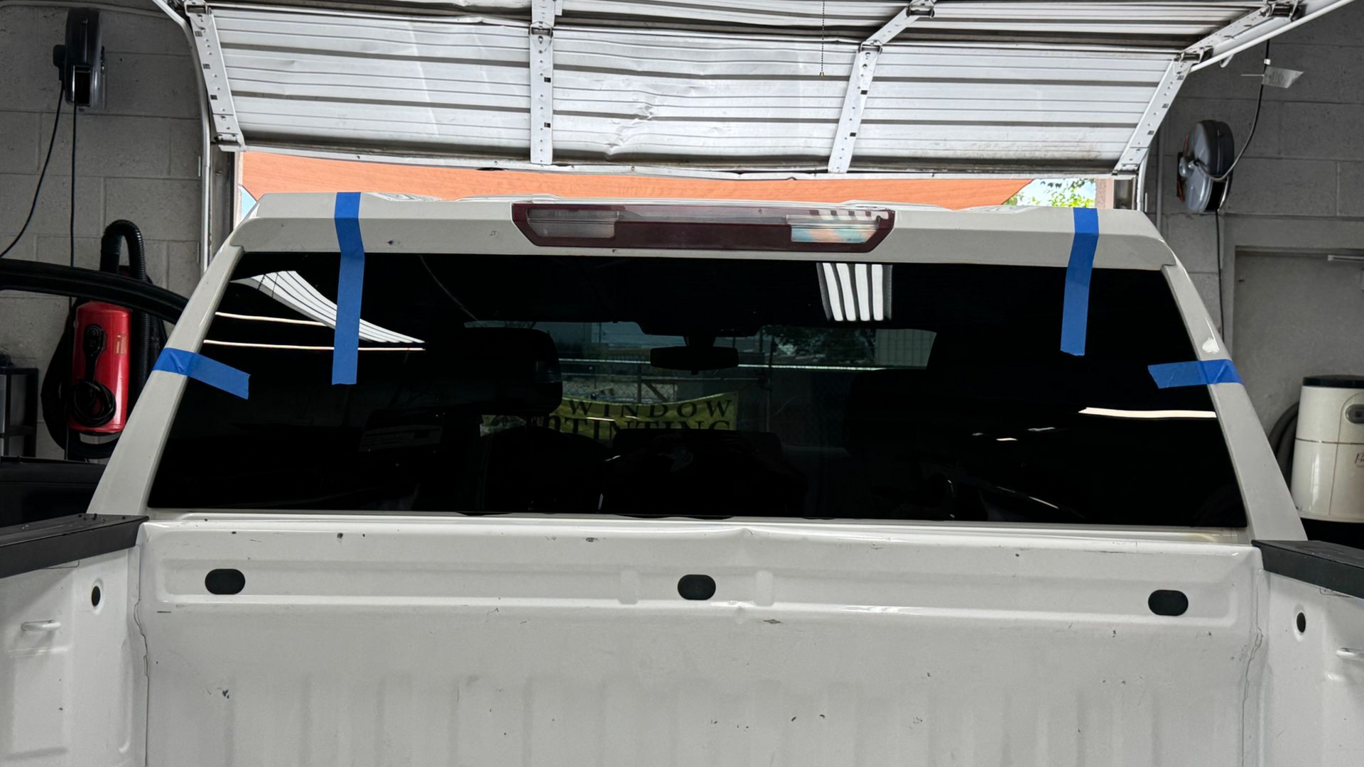 A man is cleaning the engine of a car with a towel.