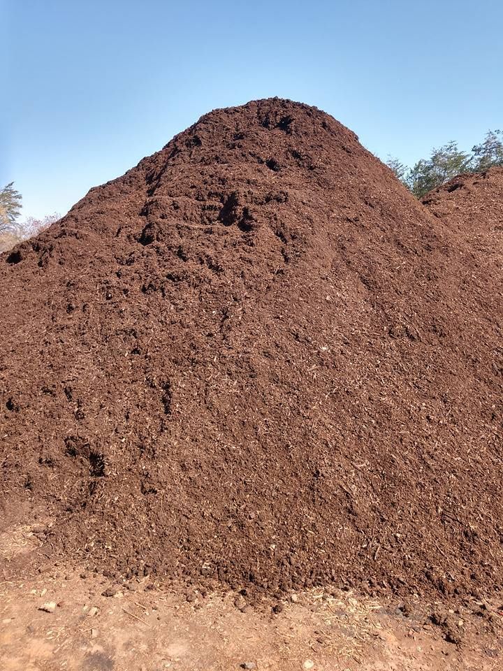 A large pile of dirt is sitting on top of a dirt field.