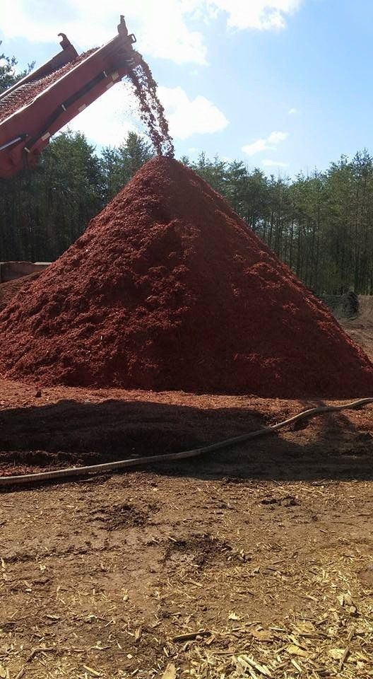 A pile of dirt is being poured into a pile of dirt.