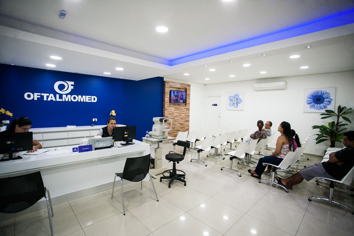 Um grupo de pessoas está sentado em uma sala de espera no consultório de um oftalmologista.