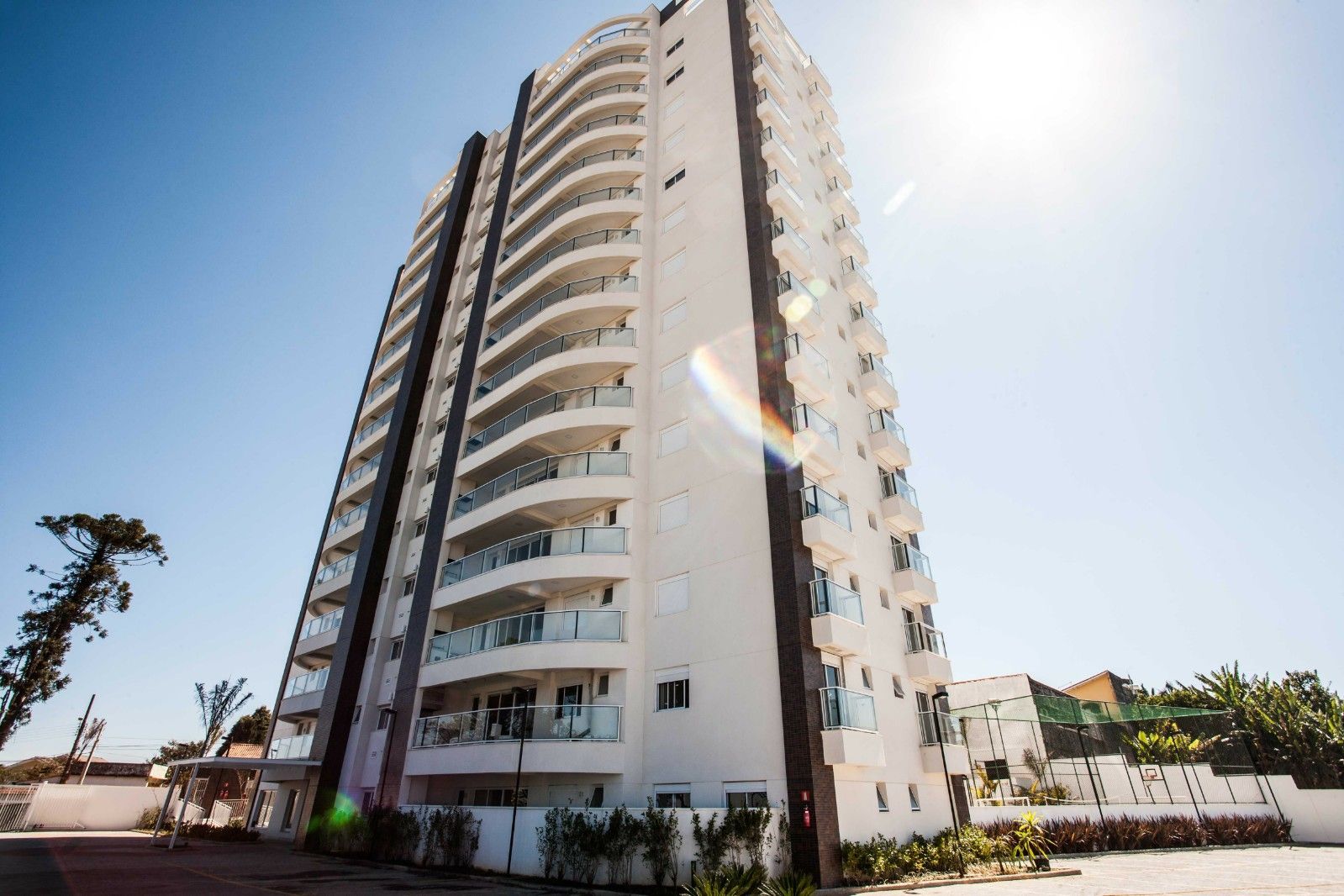 Um edifício alto com muitas janelas e varandas em um dia ensolarado.