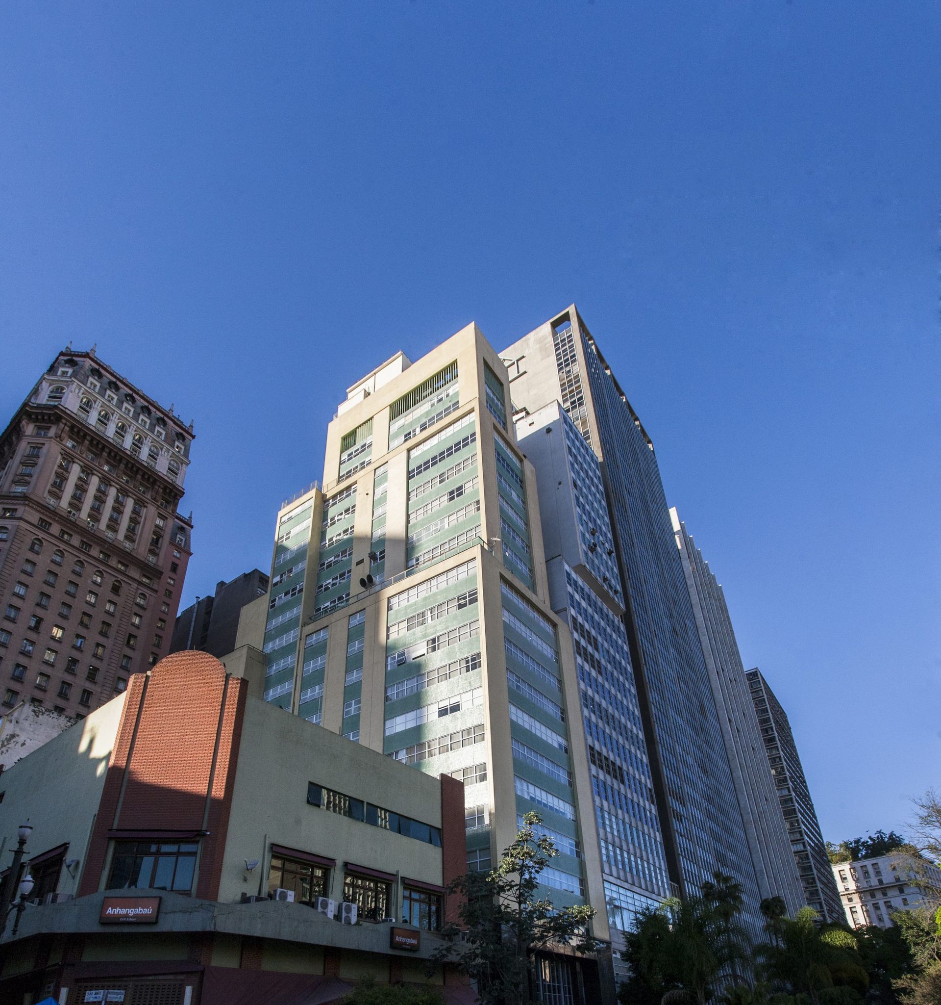 Olhando para um prédio alto com uma placa que diz 