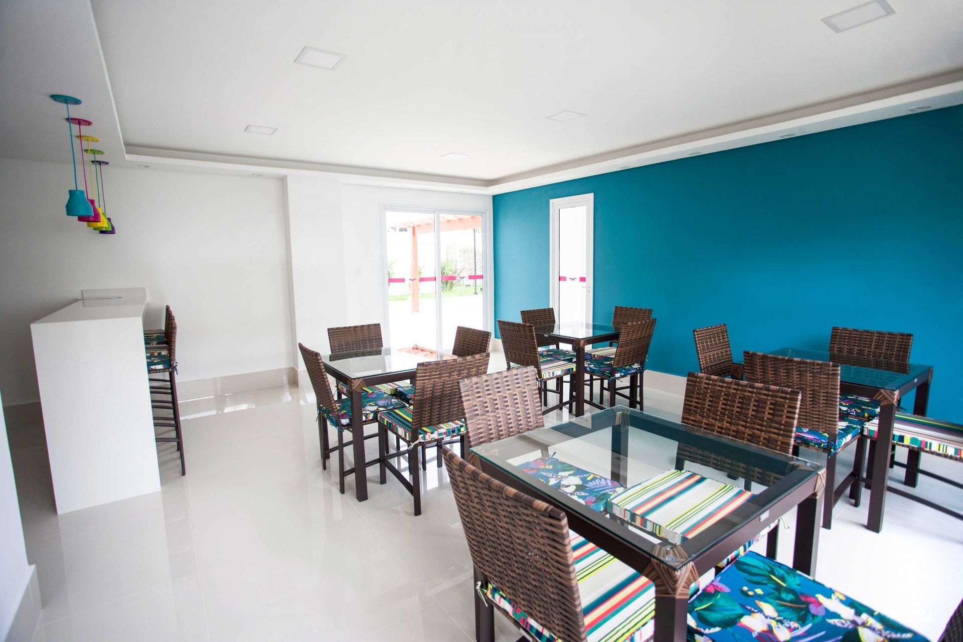 Uma sala com mesas e cadeiras e uma parede azul.