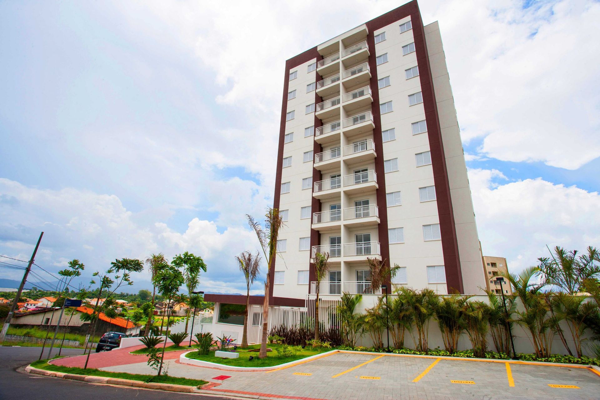 Um prédio alto com um estacionamento na frente