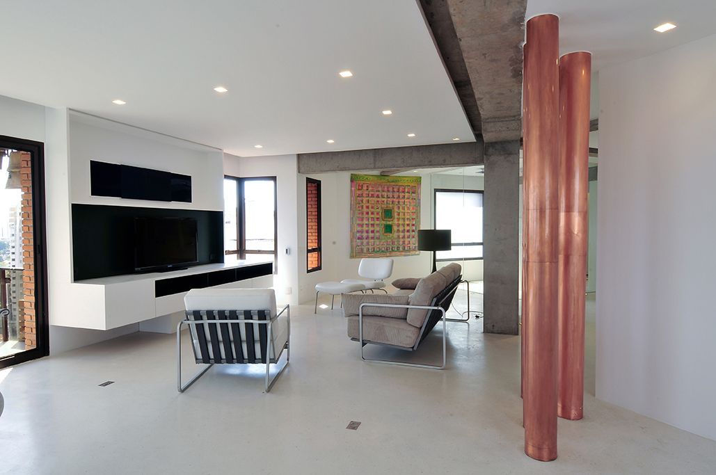 Uma sala de estar com um sofá, uma cadeira e uma televisão