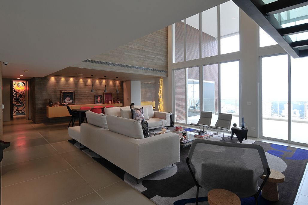 Uma sala de estar com um sofá branco e cadeiras