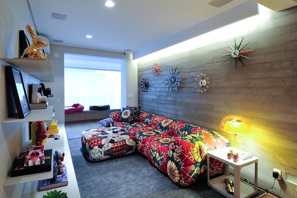 Uma sala de estar com um sofá colorido e pufe