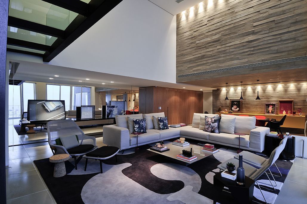 Uma sala de estar com um grande sofá secional e cadeiras