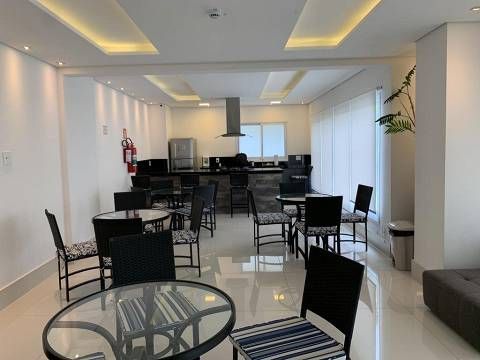 Uma sala grande com mesas e cadeiras.