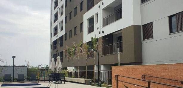 Um grande prédio de apartamentos com uma piscina na frente.