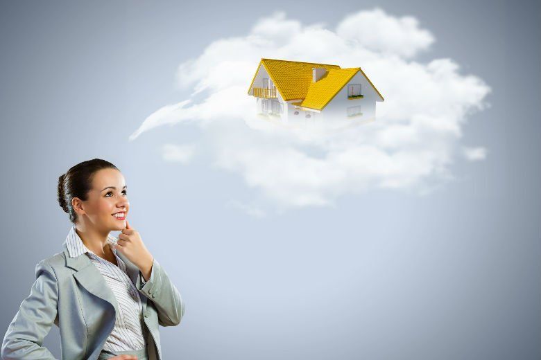 Uma mulher está olhando para uma casa nas nuvens.