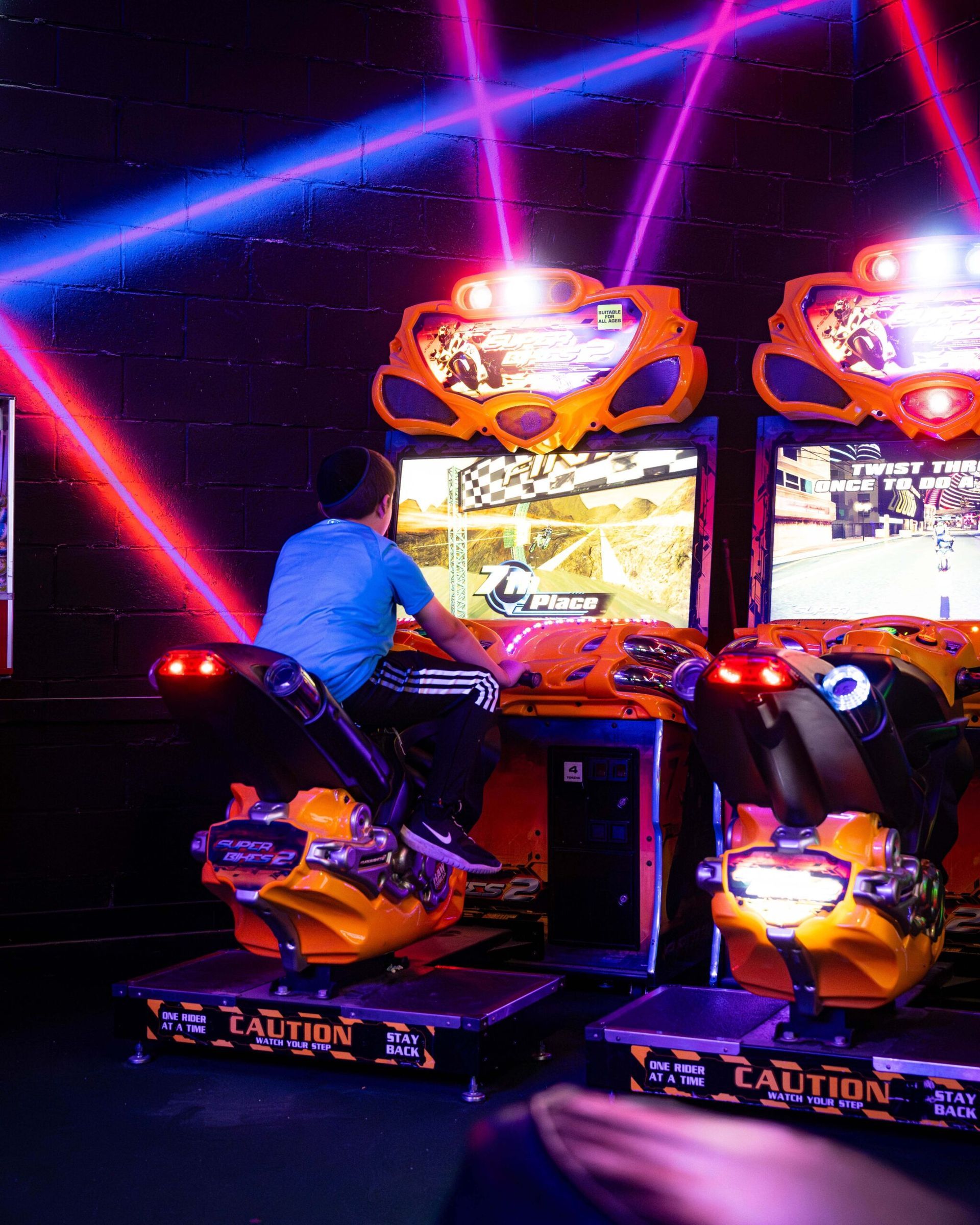 A man is playing a video game in an arcade